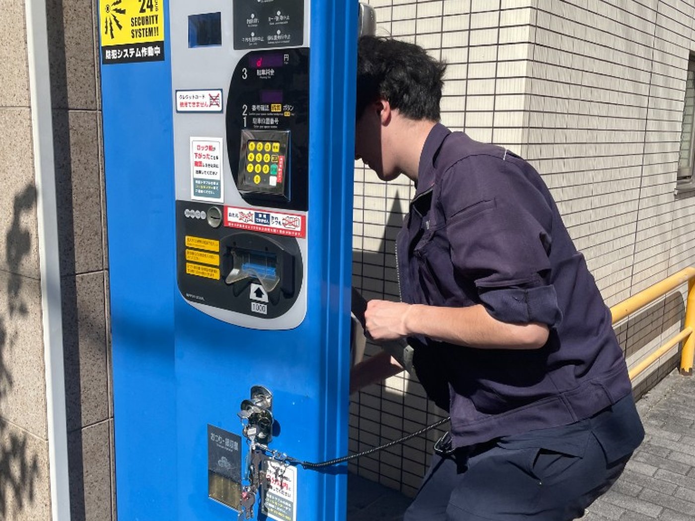 駐車場精算機の対応にあたるスタッフ